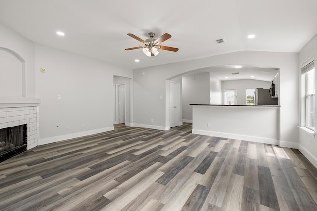 21606 Borah Peak Way, Katy, TX 77449 - unfurnished living room with a ceiling fan, recessed lighting, wood finished floors, arched walkways, and a fireplace