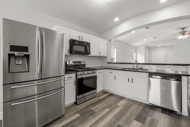 21606 Borah Peak Way, Katy, TX 77449 - kitchen with appliances with stainless steel finishes, a sink, dark countertops, vaulted ceiling, and recessed lighting