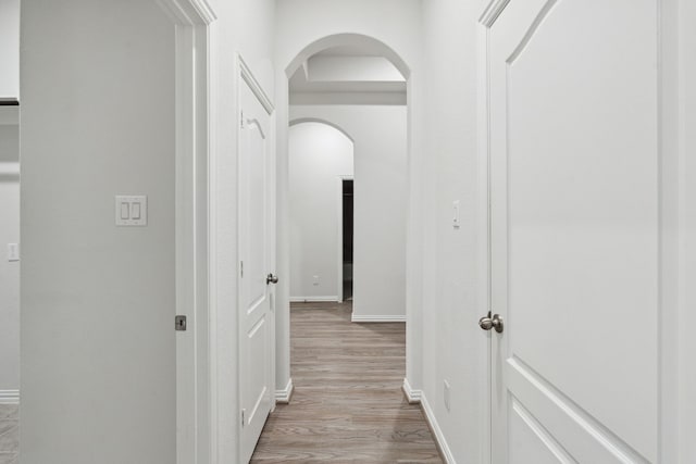 19218 Charisma Rose Ln, Tomball, TX 77377 - hallway featuring arched walkways, light wood-type flooring, and baseboards