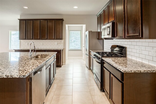 3518 Windham Way, Katy, TX 77494 - kitchen featuring stainless steel appliances, a sink, light stone countertops, dark brown cabinetry, and recessed lighting