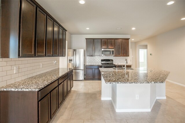 3518 Windham Way, Katy, TX 77494 - kitchen featuring stainless steel appliances, a sink, backsplash, light stone counters, and dark brown cabinetry
