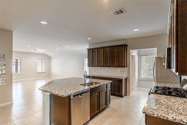 3518 Windham Way, Katy, TX 77494 - kitchen with stainless steel appliances, a sink, light tile patterned flooring, decorative backsplash, and dark brown cabinetry