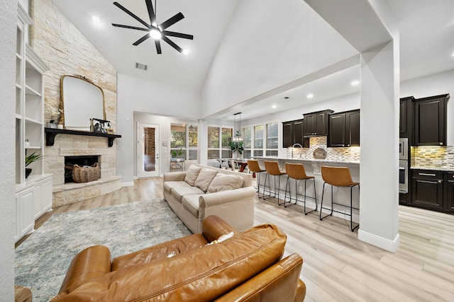 8442 Horsepen Bend Dr, Conroe, TX 77385 - living room with ceiling fan, a fireplace, light wood-style flooring, recessed lighting, and high vaulted ceiling