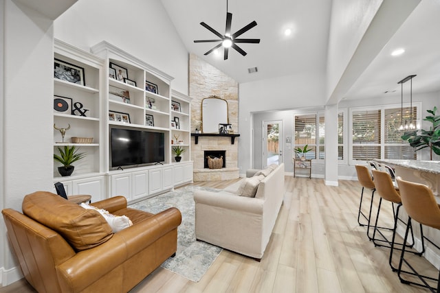 8442 Horsepen Bend Dr, Conroe, TX 77385 - living area with ceiling fan, a stone fireplace, light wood-style flooring, recessed lighting, and high vaulted ceiling