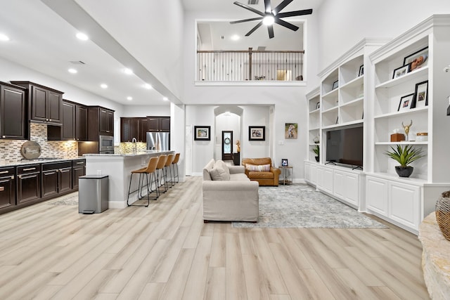 8442 Horsepen Bend Dr, Conroe, TX 77385 - living area featuring ceiling fan, light wood finished floors, recessed lighting, and a towering ceiling