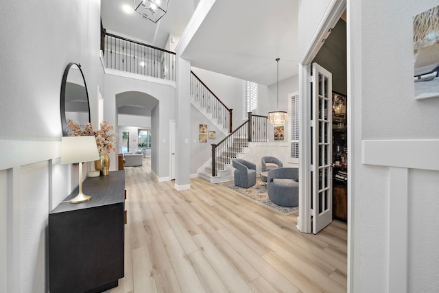 8442 Horsepen Bend Dr, Conroe, TX 77385 - foyer entrance featuring wood finished floors, stairway, arched walkways, a chandelier, and a towering ceiling