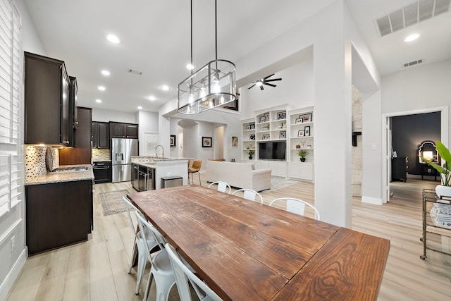 8442 Horsepen Bend Dr, Conroe, TX 77385 - dining area with light wood-style flooring, ceiling fan, recessed lighting, a high ceiling, and baseboards
