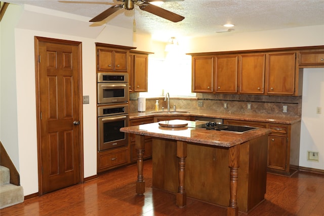 3003 Roseheath Ln, Houston, TX 77073 - kitchen with black electric stovetop, dark wood-type flooring, a center island, tasteful backsplash, and a textured ceiling