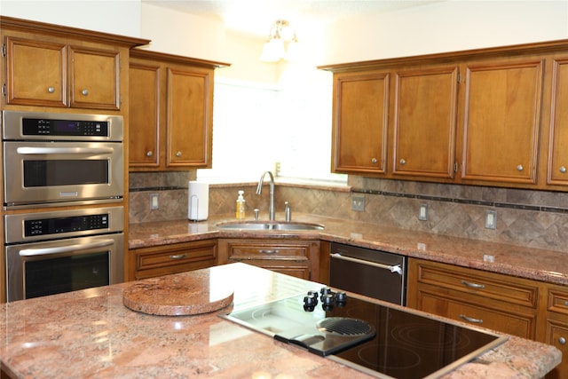 3003 Roseheath Ln, Houston, TX 77073 - kitchen with appliances with stainless steel finishes, a sink, brown cabinets, backsplash, and light stone countertops