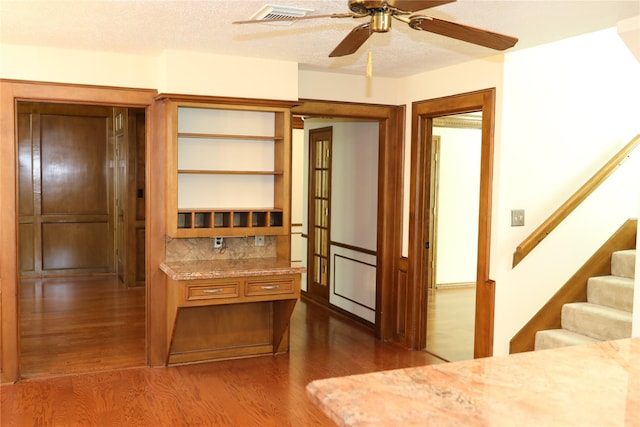 3003 Roseheath Ln, Houston, TX 77073 - bar with dark wood-type flooring, ceiling fan, decorative backsplash, stairway, and a textured ceiling