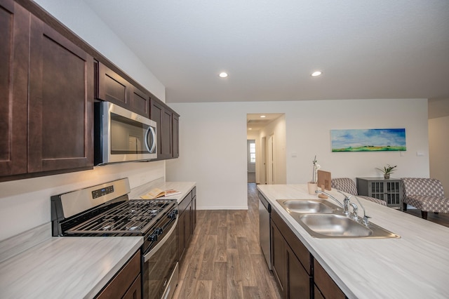 5126 Ternberry Forest Ln, Katy, TX 77449 - kitchen featuring appliances with stainless steel finishes, a sink, dark wood-type flooring, dark brown cabinets, and light countertops
