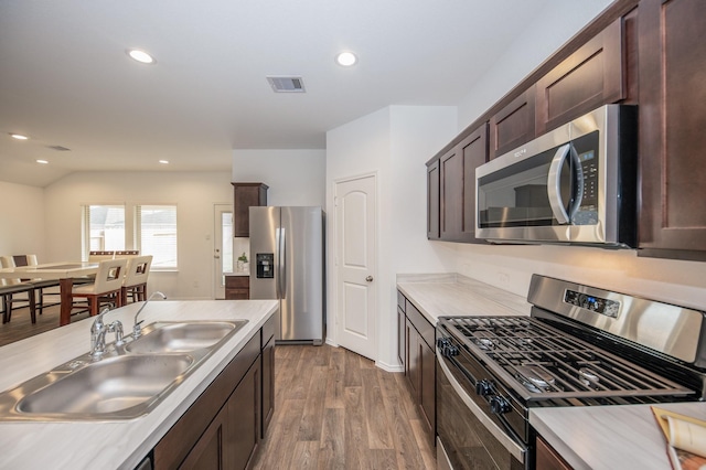 5126 Ternberry Forest Ln, Katy, TX 77449 - kitchen featuring stainless steel appliances, a sink, dark brown cabinets, light countertops, and dark wood-style floors