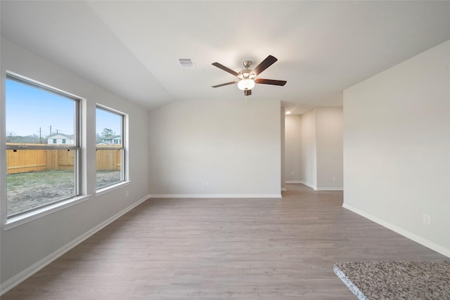 805 Clear Valley Ln, Dayton, TX 77535 - unfurnished room with light wood-style floors, ceiling fan, baseboards, and vaulted ceiling