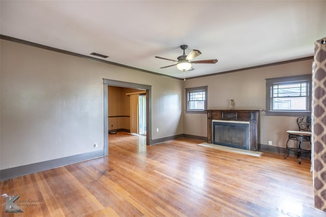 1166 Ross Ave, Abilene, TX 79605 - unfurnished living room featuring crown molding, wood finished floors, a fireplace with flush hearth, baseboards, and a ceiling fan