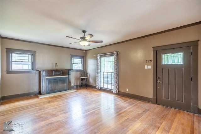 1166 Ross Ave, Abilene, TX 79605 - unfurnished living room featuring a high end fireplace, crown molding, ceiling fan, baseboards, and wood finished floors