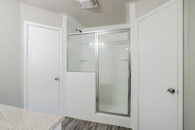 5606 Cypressgate Dr, Spring, TX 77373 - bathroom featuring a stall shower, a textured ceiling, and wood finished floors