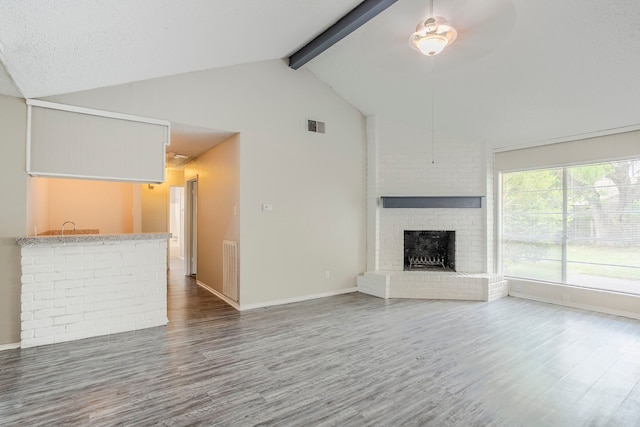 5606 Cypressgate Dr, Spring, TX 77373 - unfurnished living room featuring wood finished floors, beam ceiling, ceiling fan, a brick fireplace, and baseboards