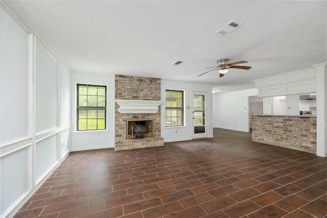 1003 Romaine Ln, Houston, TX 77090 - unfurnished living room with a fireplace, ceiling fan, a textured ceiling, and baseboards