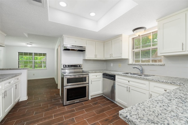 1003 Romaine Ln, Houston, TX 77090 - kitchen with appliances with stainless steel finishes, a sink, under cabinet range hood, tasteful backsplash, and baseboards