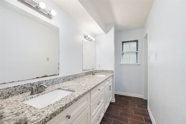 1003 Romaine Ln, Houston, TX 77090 - full bath featuring double vanity, baseboards, and wood tiled floors