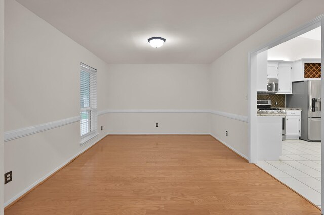 2457 Pebblebrook Cir, Conroe, TX 77384 - unfurnished dining area featuring light wood-type flooring and baseboards