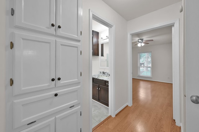2457 Pebblebrook Cir, Conroe, TX 77384 - corridor with light wood finished floors and a sink
