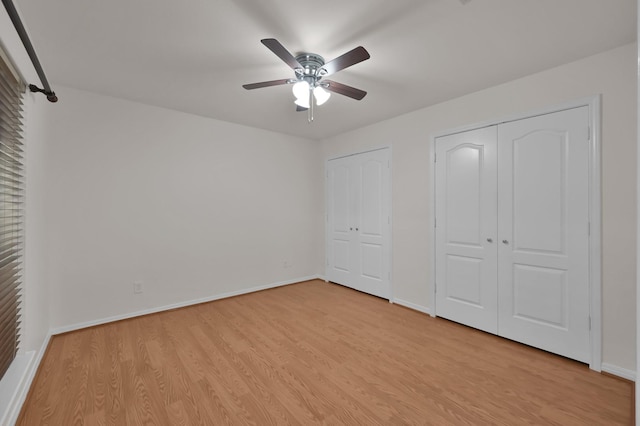2457 Pebblebrook Cir, Conroe, TX 77384 - unfurnished bedroom with multiple closets, light wood-type flooring, baseboards, and a ceiling fan