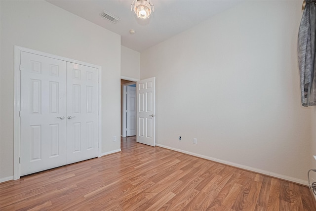 14202 Valley Bend Ct, Sugar Land, TX 77498 - unfurnished bedroom with light wood-style flooring, baseboards, a closet, and a chandelier