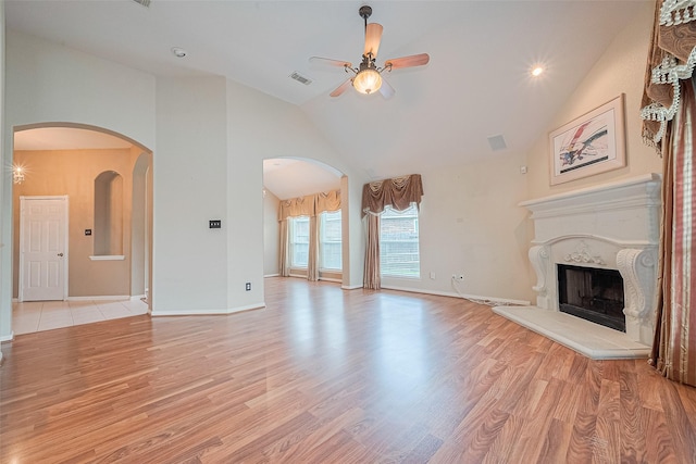 14202 Valley Bend Ct, Sugar Land, TX 77498 - unfurnished living room with a ceiling fan, high vaulted ceiling, light wood-style flooring, arched walkways, and a high end fireplace