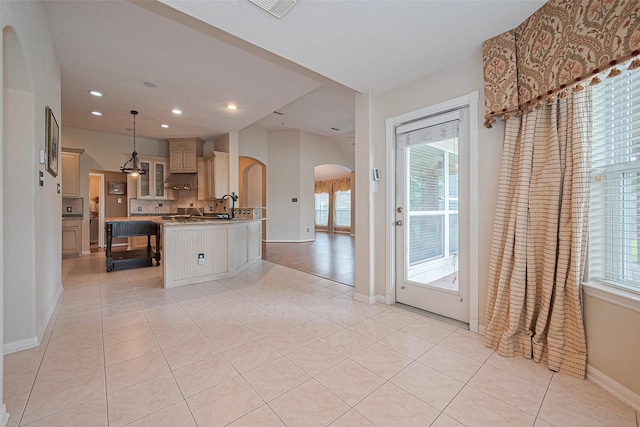 14202 Valley Bend Ct, Sugar Land, TX 77498 - kitchen featuring arched walkways, plenty of natural light, under cabinet range hood, glass insert cabinets, and recessed lighting