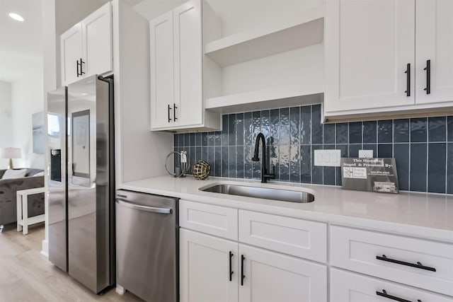 5013 Hardway St, Houston, TX 77092 - kitchen with appliances with stainless steel finishes, a sink, white cabinetry, and light countertops