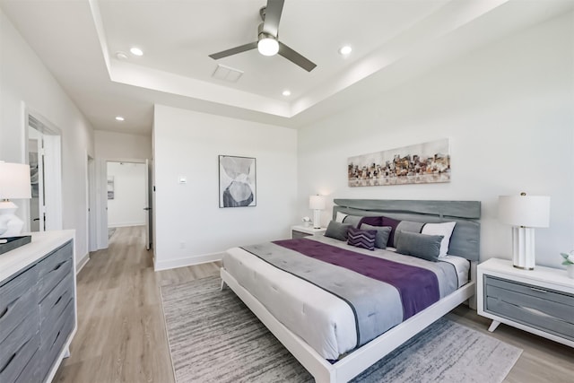 5013 Hardway St, Houston, TX 77092 - bedroom featuring light wood-type flooring, recessed lighting, a raised ceiling, ceiling fan, and baseboards