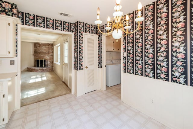 6211 Darby Way, Spring, TX 77389 - unfurnished dining area with washer / clothes dryer, a fireplace, a chandelier, light flooring, and wallpapered walls
