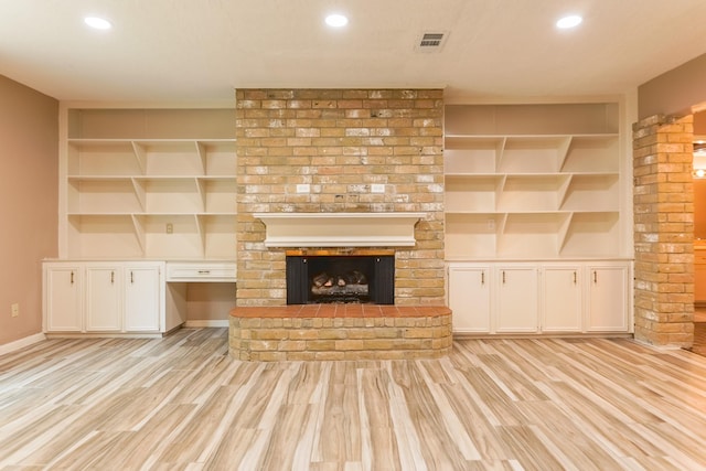 518 Lorie Ln, Pasadena, TX 77586 - unfurnished living room featuring built in shelves, light wood-style flooring, recessed lighting, baseboards, and a fireplace