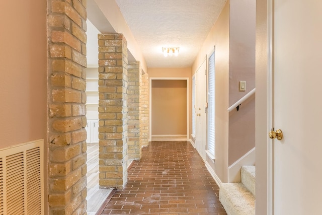 518 Lorie Ln, Pasadena, TX 77586 - corridor featuring a textured ceiling and brick floors