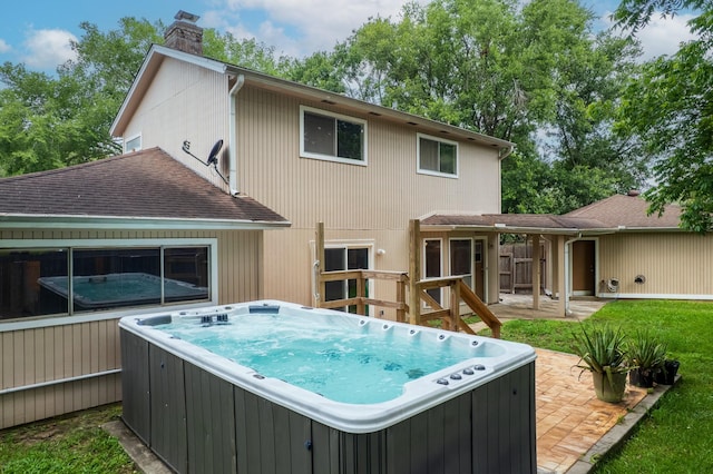 518 Lorie Ln, Pasadena, TX 77586 - back of house featuring a hot tub, a chimney, a shingled roof, and a patio