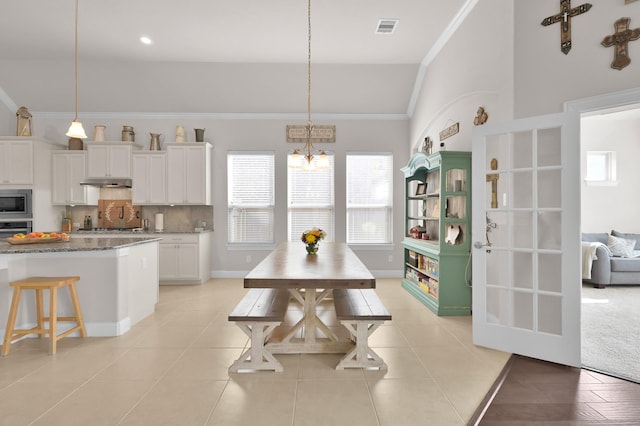 9103 Lacombe Ln, Tomball, TX 77375 - kitchen with under cabinet range hood, crown molding, white cabinets, decorative backsplash, and stainless steel appliances