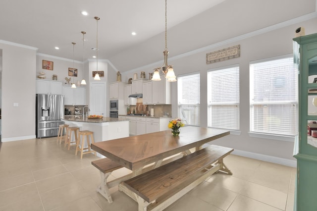 9103 Lacombe Ln, Tomball, TX 77375 - dining room with healthy amount of natural light, ornamental molding, light tile patterned flooring, baseboards, and vaulted ceiling