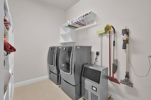 9103 Lacombe Ln, Tomball, TX 77375 - laundry area featuring washer and dryer, baseboards, and light tile patterned floors