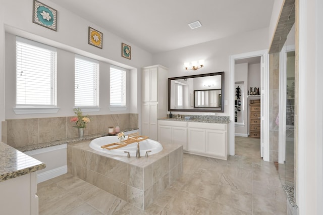 9103 Lacombe Ln, Tomball, TX 77375 - bathroom with vanity, a bath, and a walk in closet