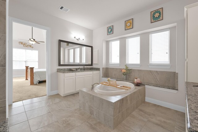 9103 Lacombe Ln, Tomball, TX 77375 - ensuite bathroom featuring a garden tub, vanity, tile patterned floors, and baseboards