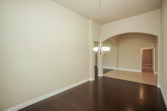 14110 Green Thicket Dr, Pearland, TX 77584 - unfurnished room featuring a chandelier, arched walkways, dark wood-type flooring, and baseboards