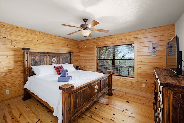 1012 Mourning Dove, Canyon Lake, TX 78133 - bedroom with light wood-style floors, wooden walls, and ceiling fan