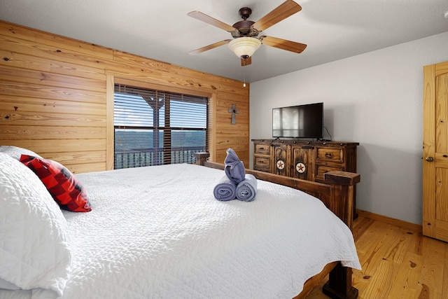 1012 Mourning Dove, Canyon Lake, TX 78133 - bedroom featuring light wood-style flooring, wood walls, baseboards, and a ceiling fan