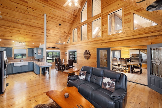 1012 Mourning Dove, Canyon Lake, TX 78133 - living area with a towering ceiling, light wood finished floors, wooden walls, and a ceiling fan