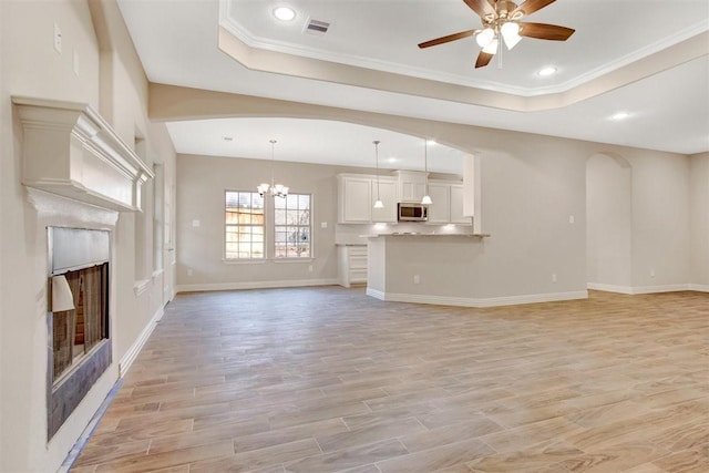 1805 Rollingwood Dr, Huntsville, TX 77340 - unfurnished living room with ceiling fan, a fireplace, a tray ceiling, light wood finished floors, and recessed lighting