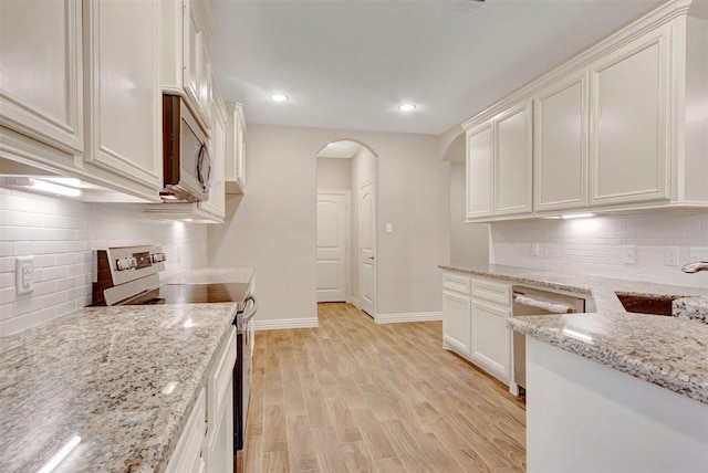 1805 Rollingwood Dr, Huntsville, TX 77340 - kitchen featuring appliances with stainless steel finishes, a sink, arched walkways, backsplash, and recessed lighting