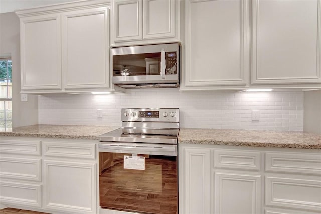 1805 Rollingwood Dr, Huntsville, TX 77340 - kitchen with appliances with stainless steel finishes, white cabinets, tasteful backsplash, and light stone countertops