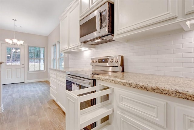 1805 Rollingwood Dr, Huntsville, TX 77340 - kitchen featuring appliances with stainless steel finishes, light wood-style floors, a chandelier, backsplash, and white cabinetry