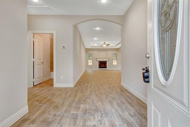 1805 Rollingwood Dr, Huntsville, TX 77340 - foyer with arched walkways, a raised ceiling, a ceiling fan, light wood-style floors, and recessed lighting